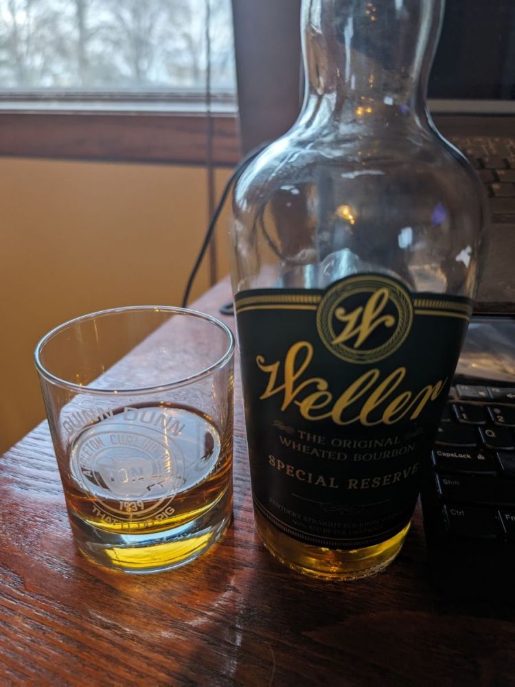 Bottle of Weller Special Reserve and Glass with Whiskey on a Desk